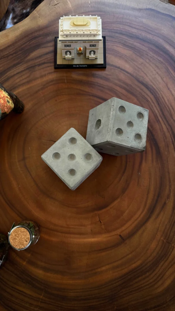 Dados de concreto utilizados como piezas decorativas sobre una mesa de centro en madera rústica