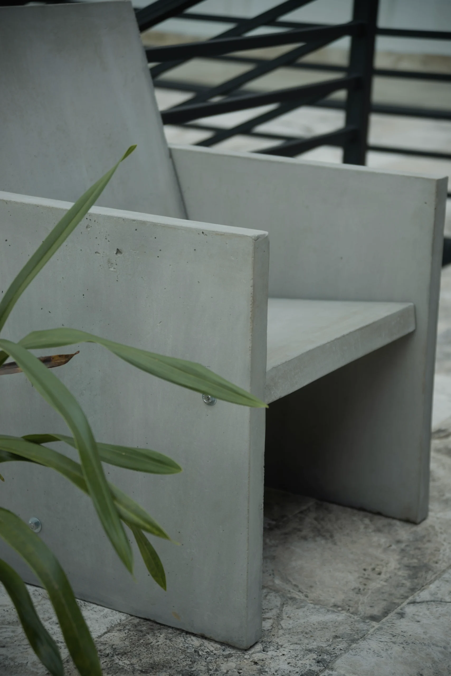 detalle-reposabrazos-sillon-concreto Acercamiento al ángulo del reposabrazos y el asiento del sillón de concreto Trono