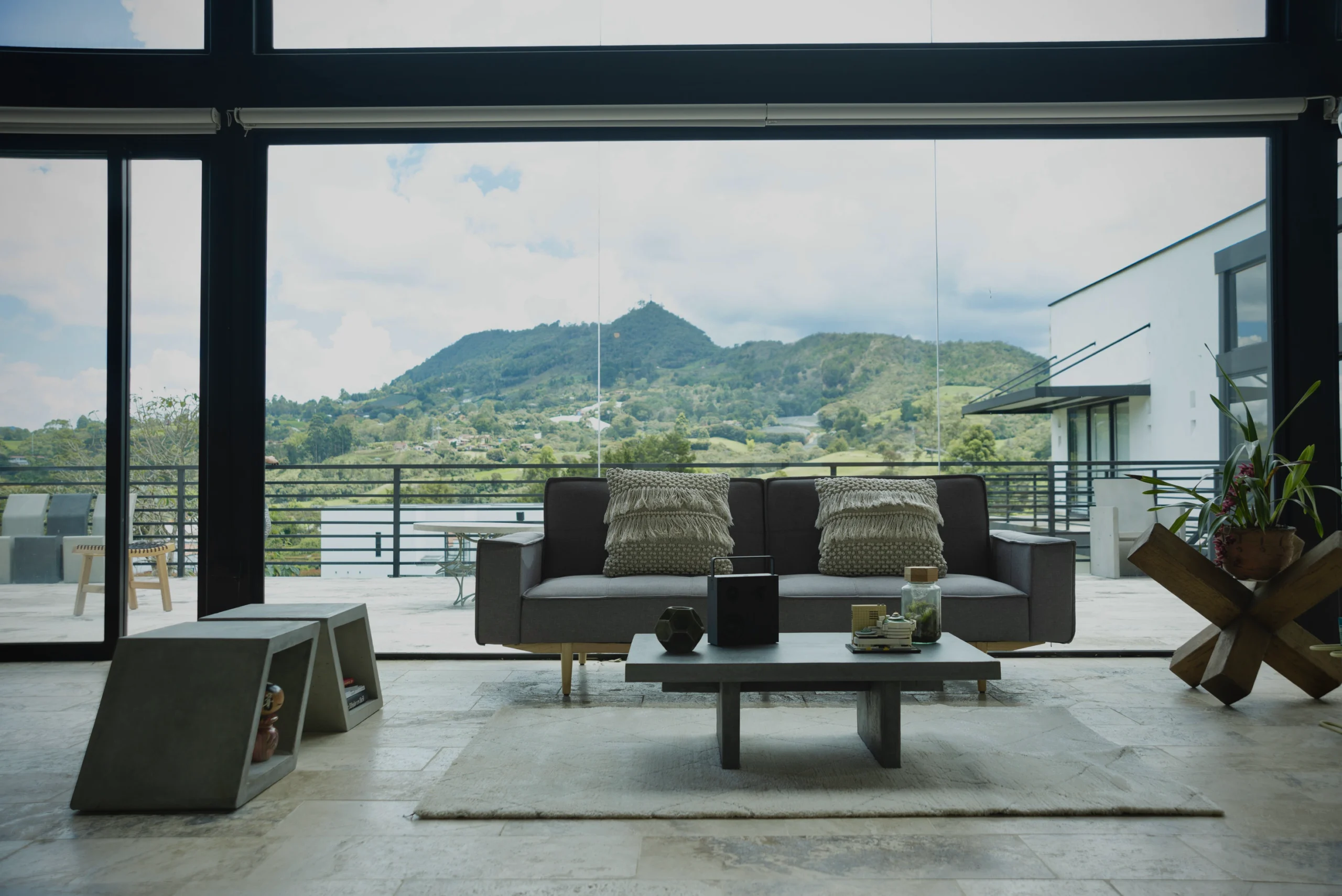 mesa-centro-concreto-sala-moderna-paisaje Mesa de centro en concreto decorando una sala moderna con ventanales y vista a la montaña